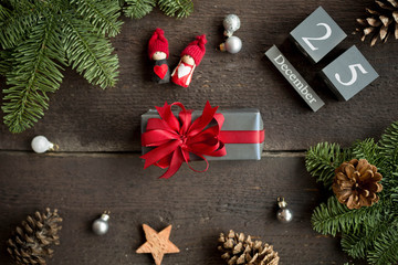 Christmas present with red ribbon, christmas calendar, pine branches, cone and xmas decorations. Christmas concept.