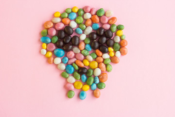 Obraz premium Skull candy scattered on a pink background