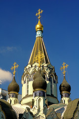 Fototapeta na wymiar Gold crosses on the dome on the blue sky background on the Church of the Resurrection in Sokolniki, Moscow, Russia. Vertical view