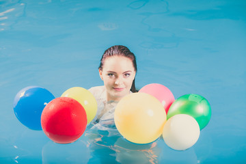 Fototapeta na wymiar Happy woman in water having fun with balloons