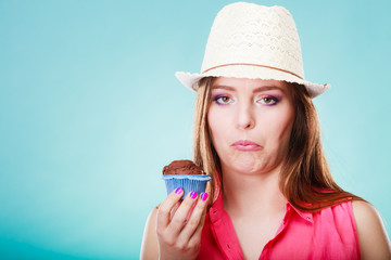 unhappy woman holds cake in hand
