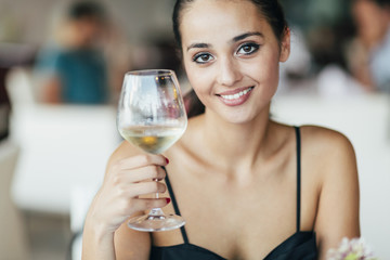 Woman tasting white wine in restaurant