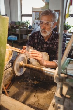 Glassblower polishing and grinding a glassware