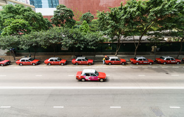 Red taxis line up on a main street, Hong Kong Island, China