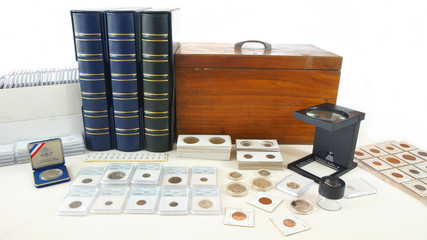 Coins of different countries of the world on white table with folders and supplies background -...