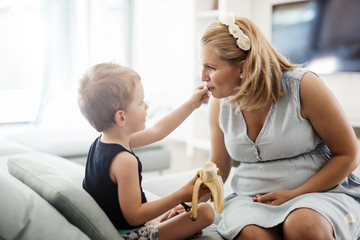 Fototapeta premium Beautiful pregnant woman caring for son