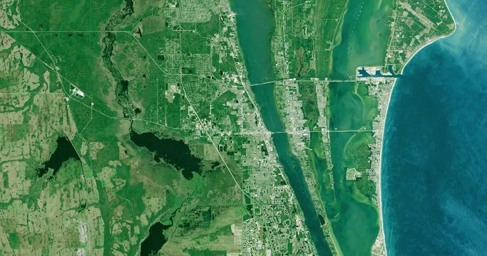 High-altitude overflight aerial of Kennedy Flight Center and adjacent coastland. Clip loops and is reversible. Elements of this image furnished by USGS/NASA Landsat 
