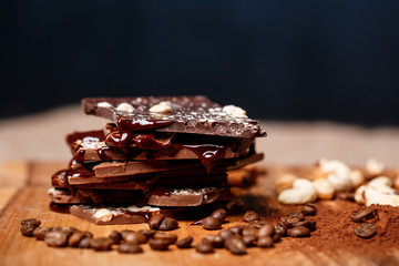Chocolate and nuts over black background.