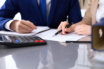 Bookkeeper or financial inspector and secretary making report, calculating or checking balance. Internal Revenue Service inspector checking financial document. Audit concept.