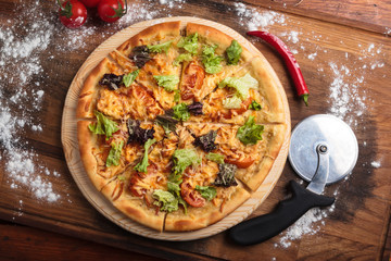 Concept: restaurant menus, healthy eating, homemade, gourmands, gluttony. Caesar pizza on messy wooden background. Top-down view.