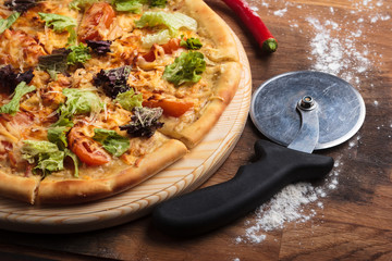 Concept: restaurant menus, healthy eating, homemade, gourmands, gluttony. Caesar pizza on messy wooden background.