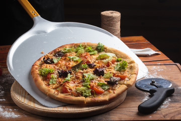 Concept: restaurant menus, healthy eating, homemade, gourmands, gluttony. Caesar pizza on messy wooden background.