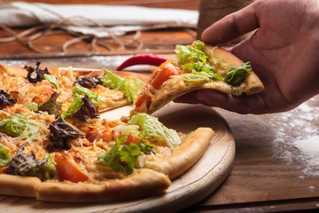 Concept: restaurant menus, healthy eating, homemade, gourmands, gluttony. Caesar pizza on messy wooden background.