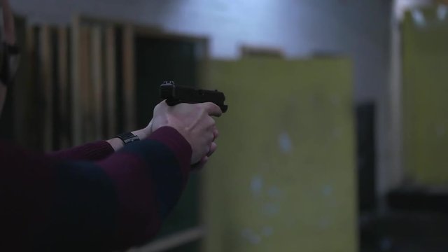 man shoots a gun at shooting range.