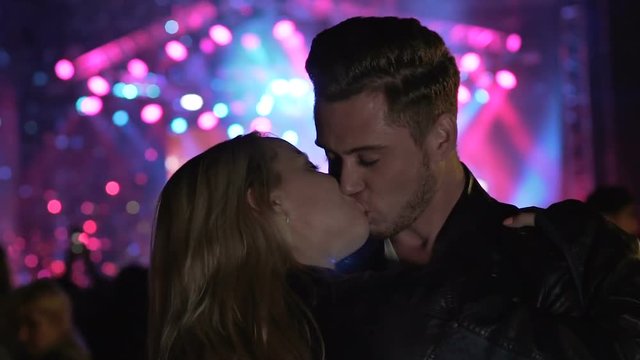 Young people hooking up in night club, couple kissing and dancing at party