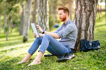 Businessman using tablet in park