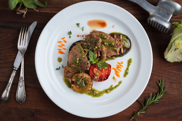Concept: restaurant menus, healthy eating, homemade, gourmands, gluttony. White plate of veal medallions with grilled vegetables and 