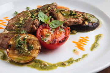 Concept: restaurant menus, healthy eating, homemade, gourmands, gluttony. White plate of veal medallions with grilled vegetables and 