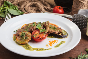 Concept: restaurant menus, healthy eating, homemade, gourmands, gluttony. White plate of veal medallions with grilled vegetables and 