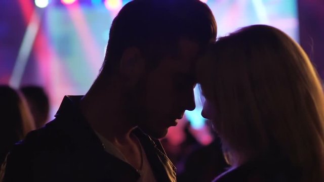 Couple in love cuddling and dancing with eyes closed, enjoying date at party