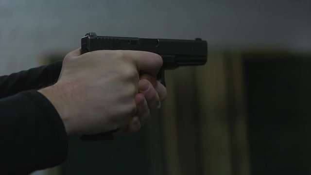 man shoots a gun at shooting range close up.