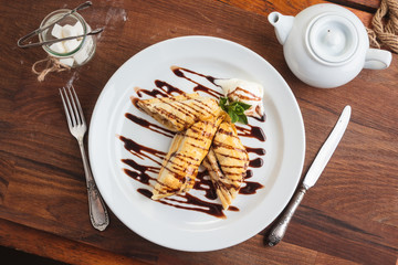 Concept: restaurant menus, healthy eating, homemade, gourmands, gluttony. White plate of strudel with apple on vintage wooden table. Top-down view