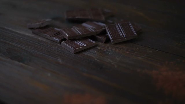 Cocoa powder in glass cup on wooden table. Dark chocolate bar. Closeup of raw dessert. Sweet ingredient for cooking cake. Chocolate chunks. Black chocolate stack. Delicious dessert. Sweet food