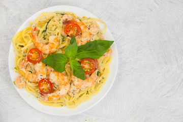 delicious delicious spaghetti with shrimps and basil on  plate
