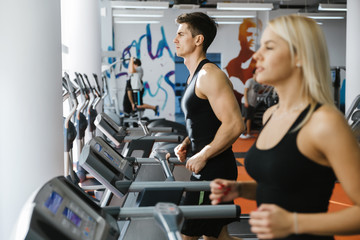 People running on treadmills in gym