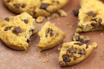Broken chocolate chip cookies on a tiled worktop