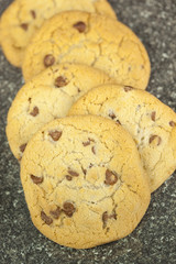 Freshly baked chocolate chip cookies on a granite worktop