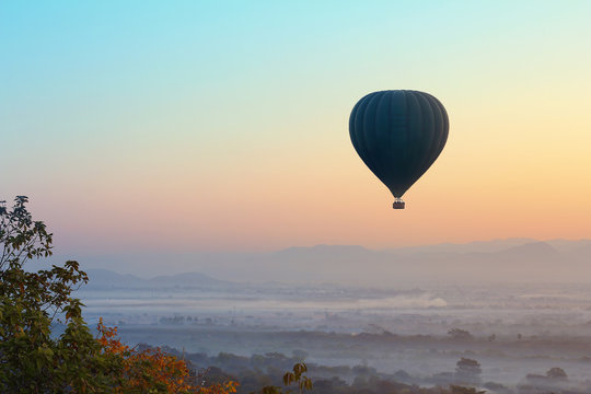 Hot air balloon over plain of Mandalay in Myanmar. this is a vehicle for tourists to see the beautiful scenery during sunrise,sunset over mandalay city.