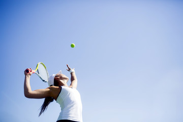 Beautiful female tennis player serving - obrazy, fototapety, plakaty