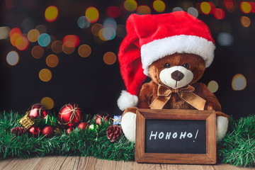 Teddy Bear and Santa  Hat in Christmas with Black Board and Blur