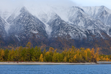 Coast with autumn forest on mountains background