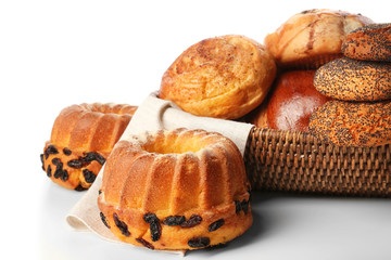 Assortment of fresh pastries with wicker bowl on white background