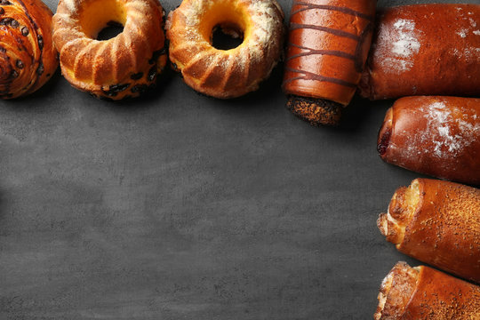 Frame of assorted fresh pastries on grey background