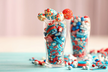 Glasses with colorful small candies on table