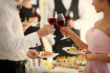 People clinking glasses at buffet catering party