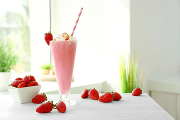 Delicious milkshake on table in kitchen