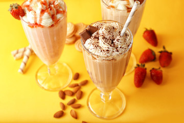 Delicious milkshakes on yellow background