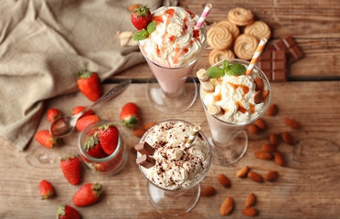 Delicious milkshakes on wooden background