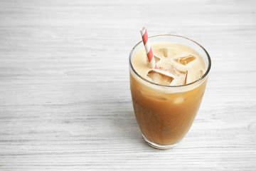 Glass of cold coffee on wooden background