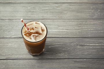 Glass of cold coffee on wooden background