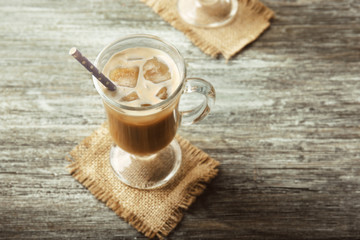 Glass of cold coffee on table