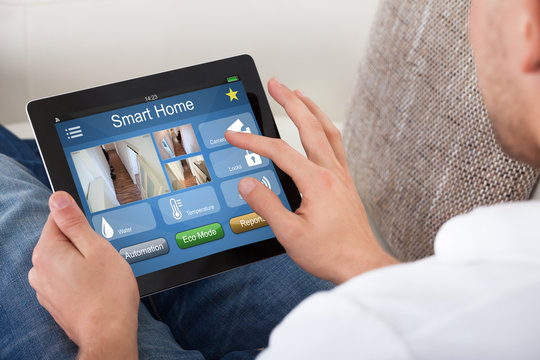 Person Using Home Control System On A Digital Tablet