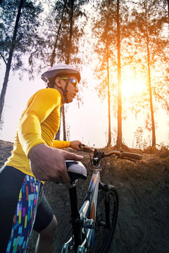 young man and mountain bicycle against sun light for people spor