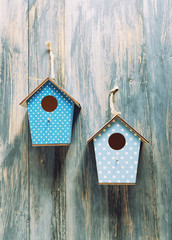 two birdhouses on antique rustic wood background.