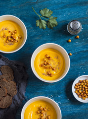 Pumpkin soup with spicy baked chickpea. On a wooden table, top view. Flat lay