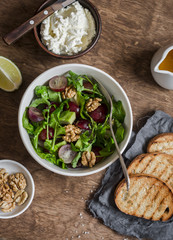 Avocados, grapes and arugula salad. On a wooden table, top view